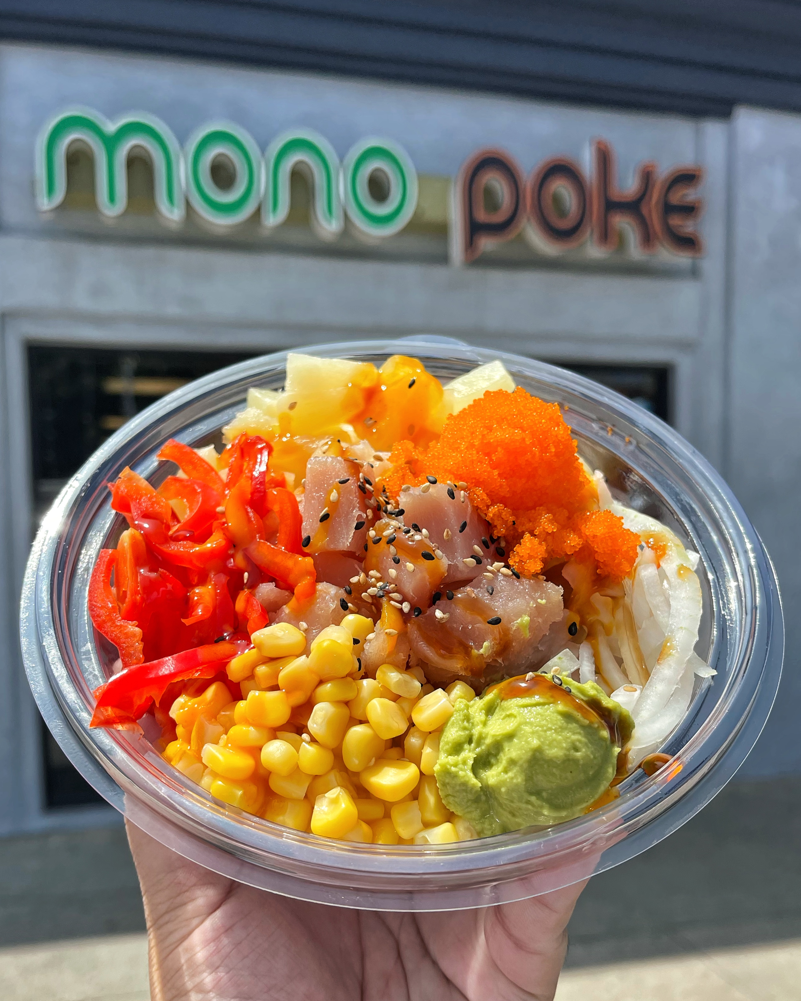 A poke bowl from MonoPoke in front of the store
